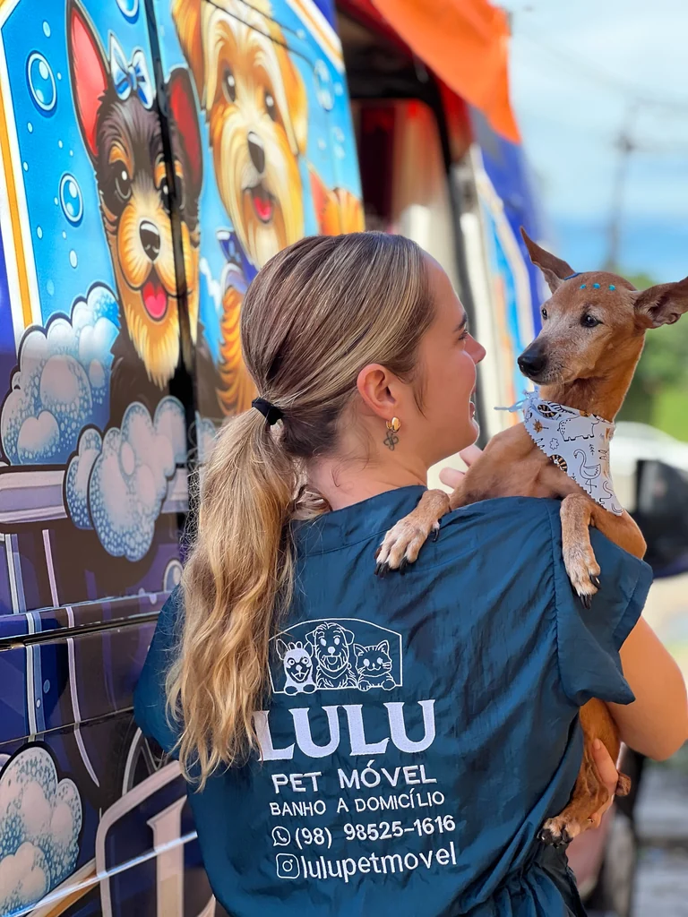 Profissional da Lulupet acolhendo um cão ao lado da unidade móvel